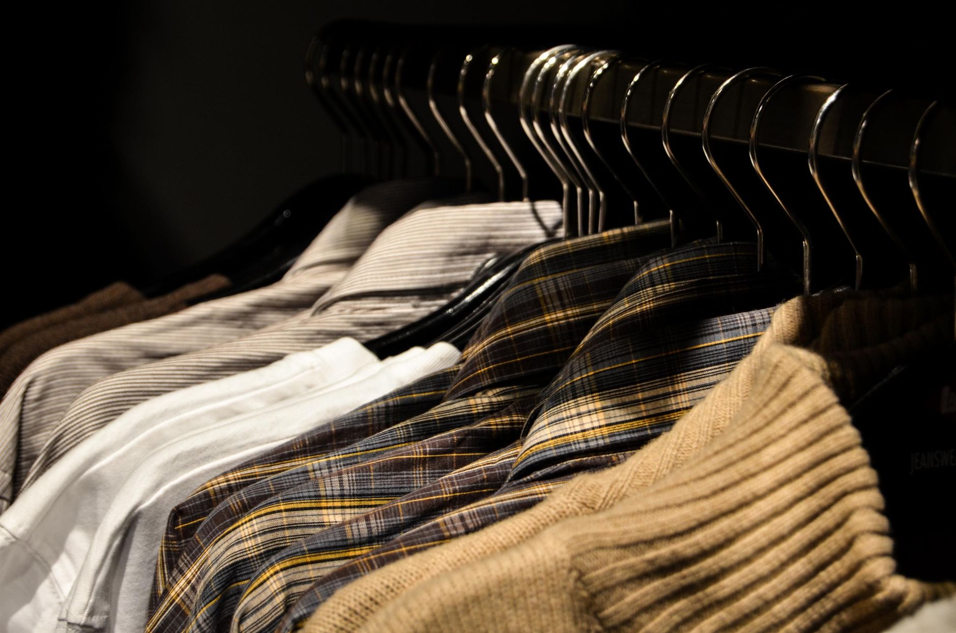 Exhibición ordenada de camisas variadas en perchas